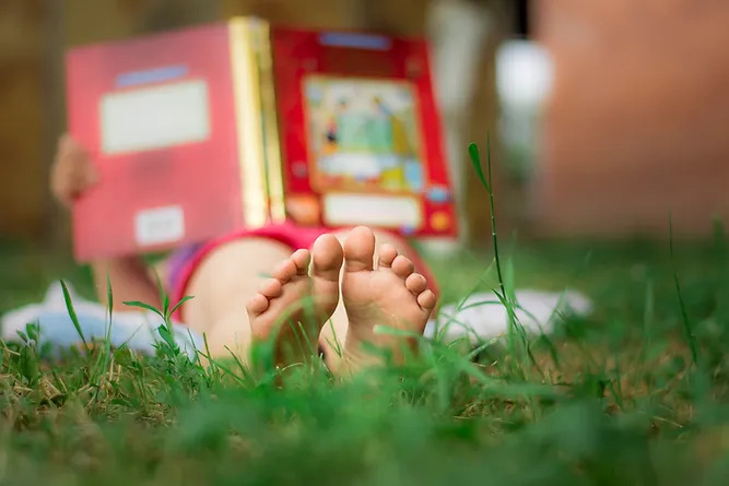 Child Reading in the Grass